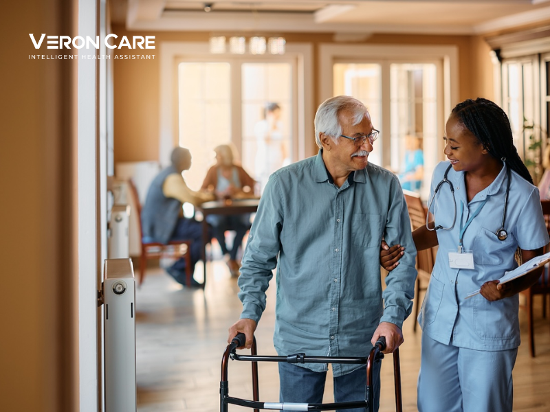 Caregiver assisting an elderly resident in assisted living with Veron Care safety monitoring